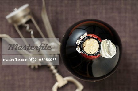 Overhead View of Bottle of Red Wine and Corkscrew on Grey Background, Studio Shot