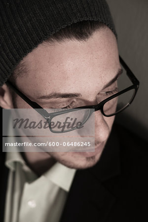 Close-up, High Angle View of Young Man wearing Woolen Hat and Eyeglasses, Studio Shot