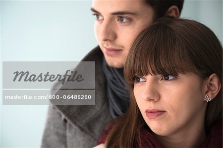 Close-up, Head and Shoulder Portrait of Young Couple Looking to the Side, Studio Shot on Grey Background