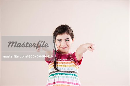 Portrait of Girl Pointing at Camera in Studio