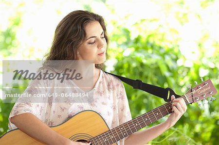 Woman playing guitar outdoors