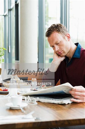 Businessman reading at breakfast