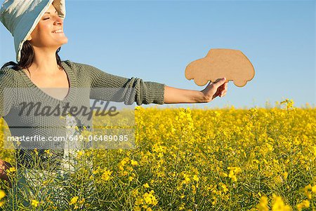 Woman holding car shape outdoors