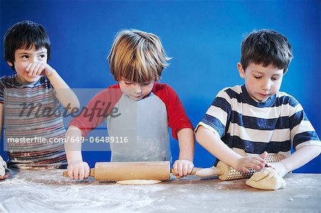 Boys rolling out dough with pins