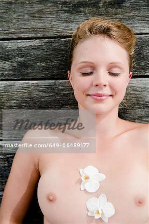 Nude woman laying on wooden deck