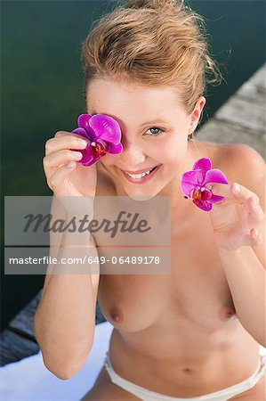 Nude woman playing with flowers