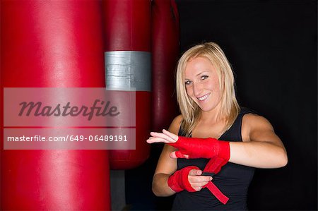 Boxer wrapping her hands in gym