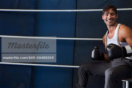 Smiling boxer sitting in ring