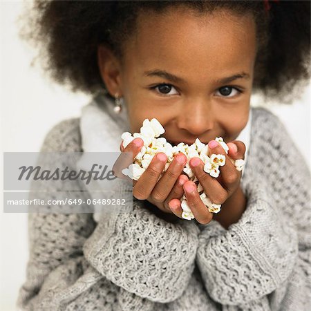 Girl eating handful of popcorn