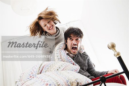 Smiling couple playing in bed