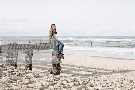 Woman on abandoned pier on beach