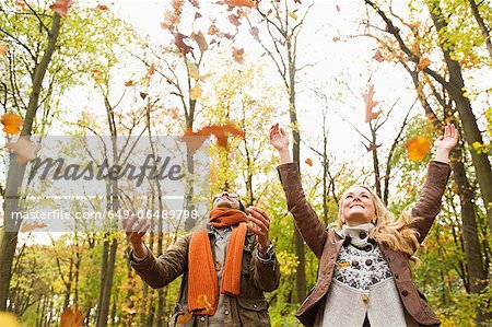 Smiling couple playing in autumn leaves