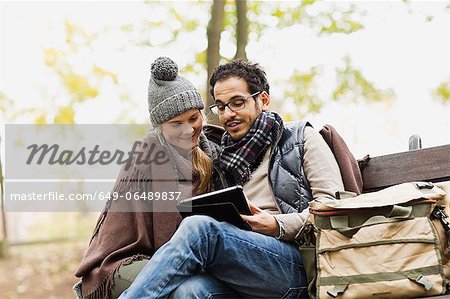 Couple using tablet computer in park