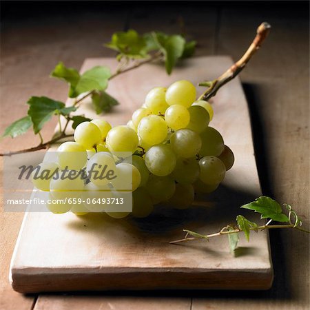Green grapes on a wooden board Green grapes on a wooden board