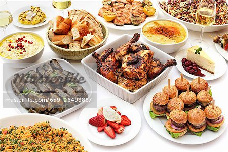 Chicken, stuffed vine leaves and mini burgers on a buffet