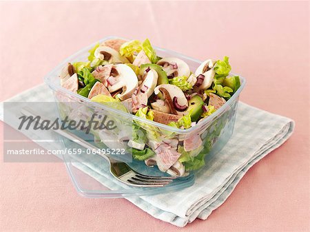 Mushrooms salad with avocado and sausage in a lunchbox