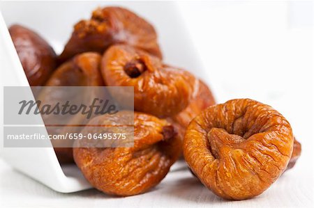 Dried figs falling out of a bowl