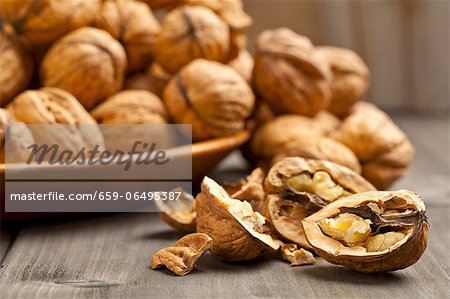 Whole and halved walnuts on a wooden table Whole and halved walnuts on a wooden table