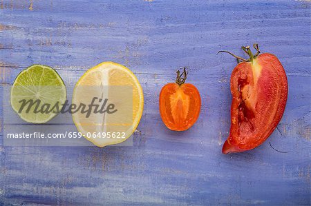 A lime, a lemon, a yellow tomato and an Andenhorn tomato