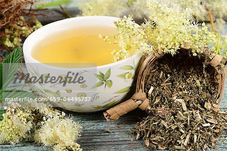 A bowl of meadowsweet tea and tea leaves in a tea strainer