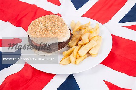 Close-up of hamburger and chips over British flag