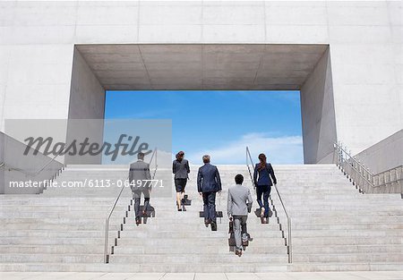 Business people ascending modern stairs
