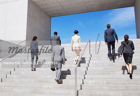 Business people ascending urban stairs