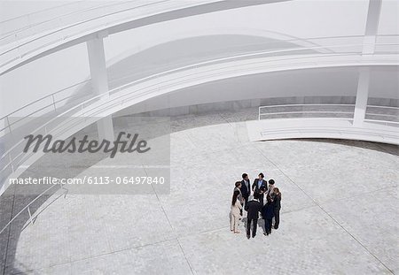 Business people standing in circle of modern courtyard