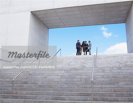 Business people meeting at top of urban stairs