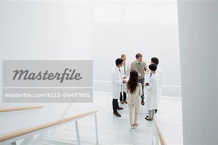 Business people and doctors on landing of stairs