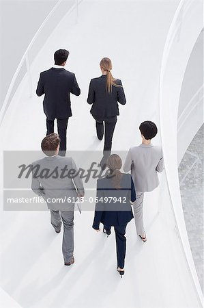 Business people ascending elevated walkway