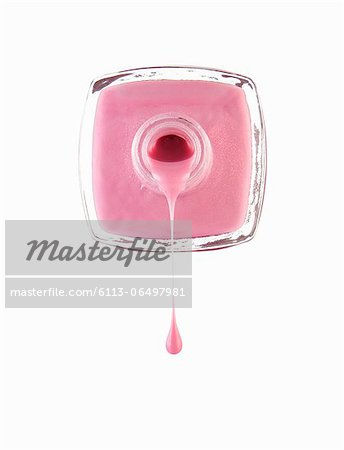Close up of pink fingernail polish dripping from bottle
