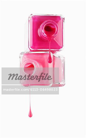 Close up of pink fingernail polish dripping from bottles