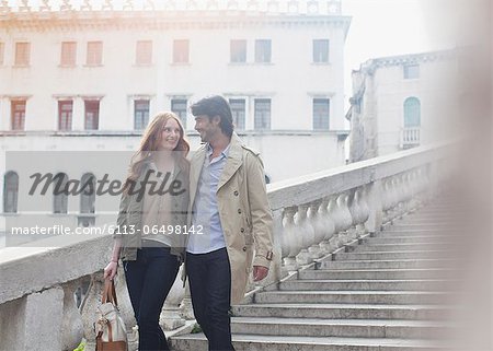 Smiling couple descending stairs in Venice