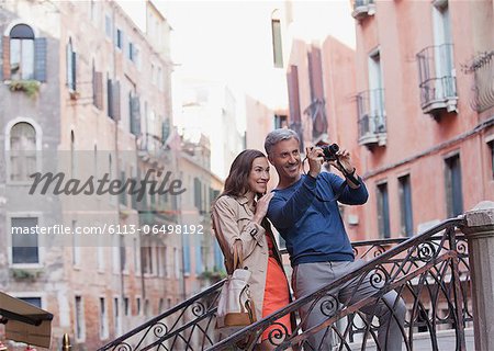 Smiling couple taking photograph in Venice
