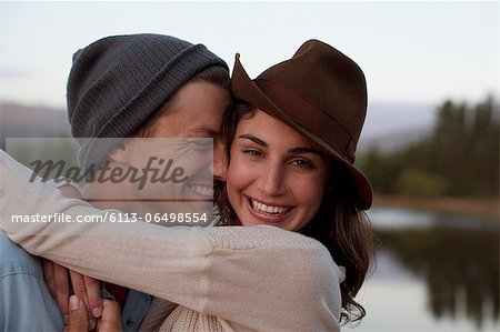 Close up portrait of happy couple hugging at lakeside