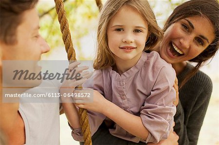 Portrait of happy family on swing