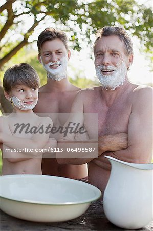 Portrait of multi-generation men with arms crossed and shaving cream on faces