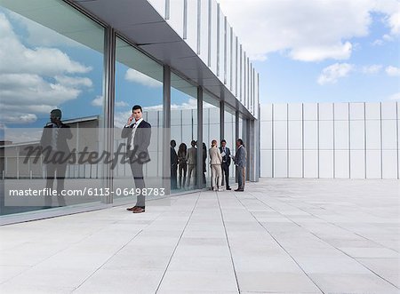 Businessman talking on cell phone outside building