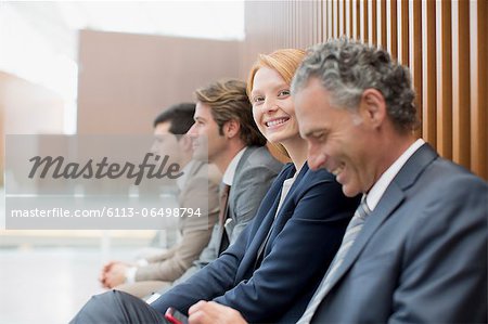 Portrait of smiling businesswoman sitting with businessmen