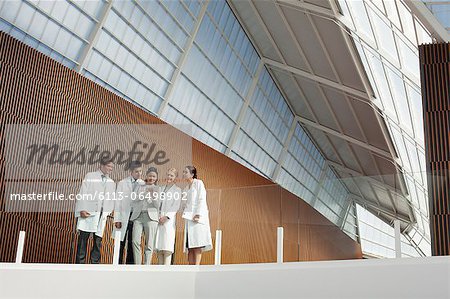 Doctors and businesswoman using digital tablet on modern balcony