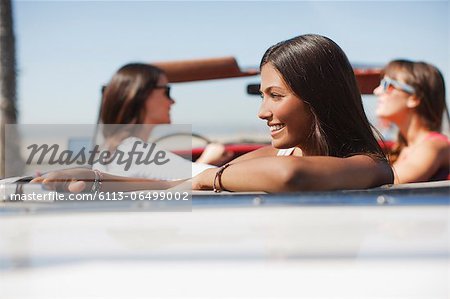 Smiling woman sitting in convertible