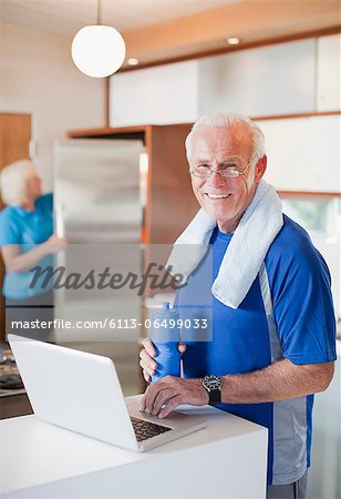 Older man using laptop after workout