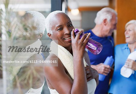 Older woman drinking water after workout