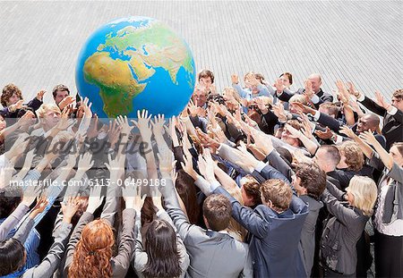 Crowd of business people reaching for globe