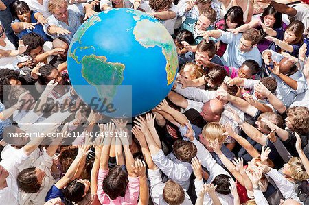 Crowd of people reaching for globe