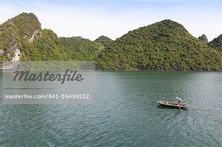 A man in a fishing boat, Ha Long Bay, UNESCO World Heritage Site, Vietnam, Indochina, Southeast Asia, Asia