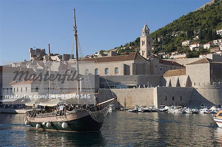 Tourist boat in the old harbour with the bell tower of the Franciscan Monastery in the background, Old Town, Dubrovnik, UNESCO World Heritage Site, Croatia, Europe