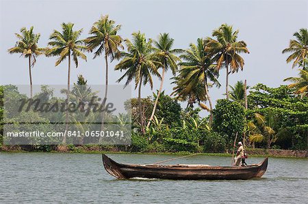Fisherman in traditional boat on the Kerala Backwaters, Kerala, India, Asia