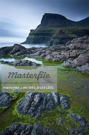 Algae lined rockpools on the coast at Gasadalur on the island of Vagar, Faroe Islands, Denmark, Europe